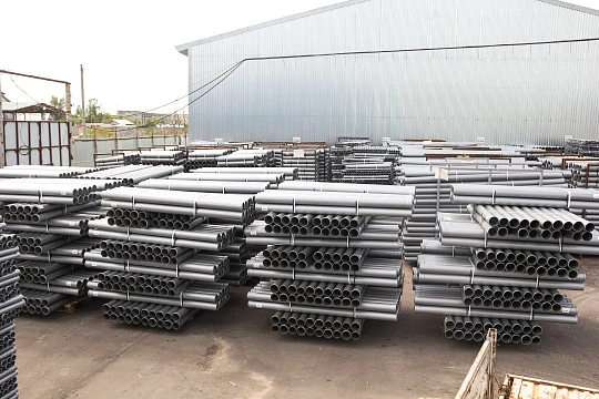 Склад готовой продукции с серыми ПВХ трубами для оптовых поставок